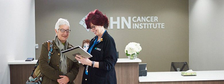 Two women smiling and looking at a digital tablet at the AHN Cancer Insitute