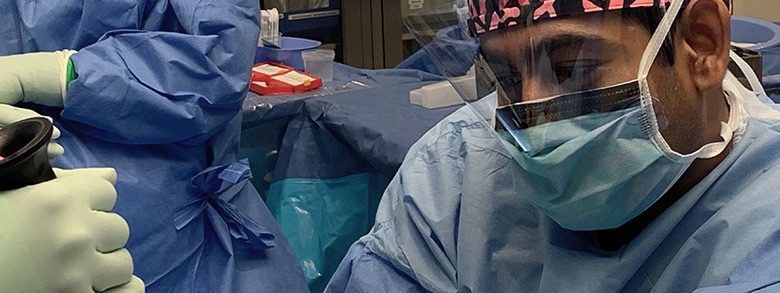 Medical professionals dressed in scrubs in an operating room during surgery